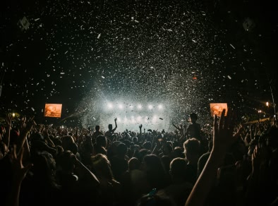 A crowd dancing outside at a night time music festival 