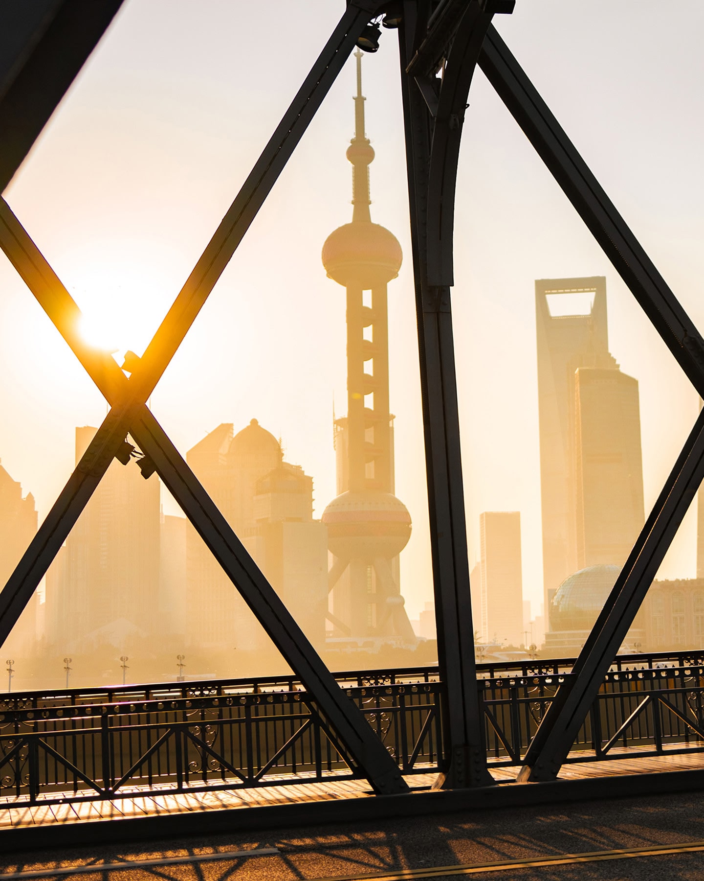 A sunset view of the Shanghai skyline seen from a bridge.