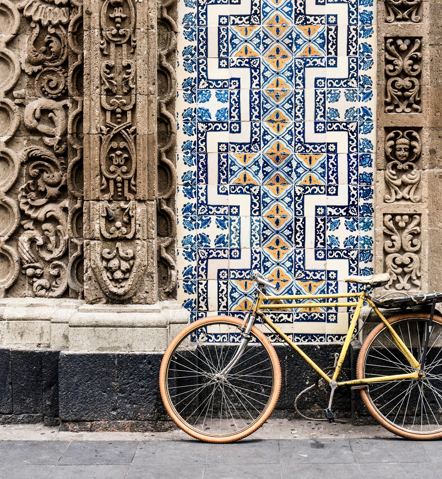 A bike stands in front of an elaborate and colourful tile composition in Mexico City.