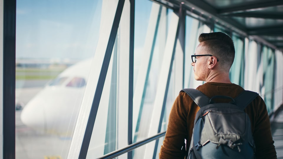 Mann am Flughafen schaut aus dem Fenster