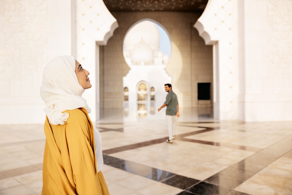 Une femme admire la Grande Mosquée Sheikh Zayed alors qu'un homme la précède.