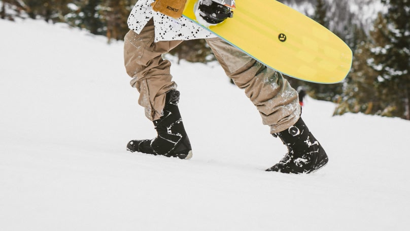 보드를 들고 슬로프를 걸어가는 사람의 다리