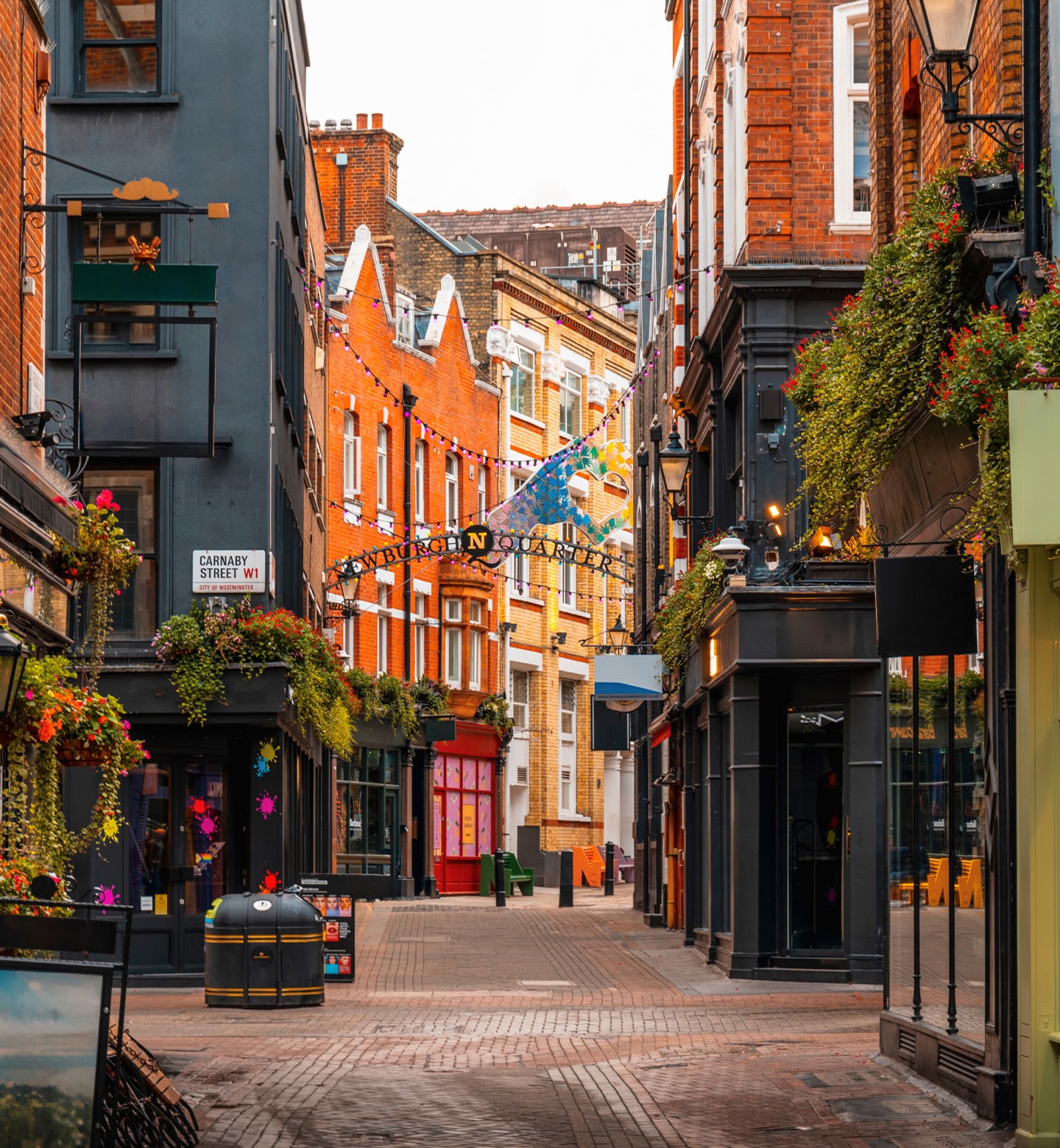Colourful shop fronts and window boxes filled with blooming flowers on the famous Carnaby Street, London, United Kingdom.