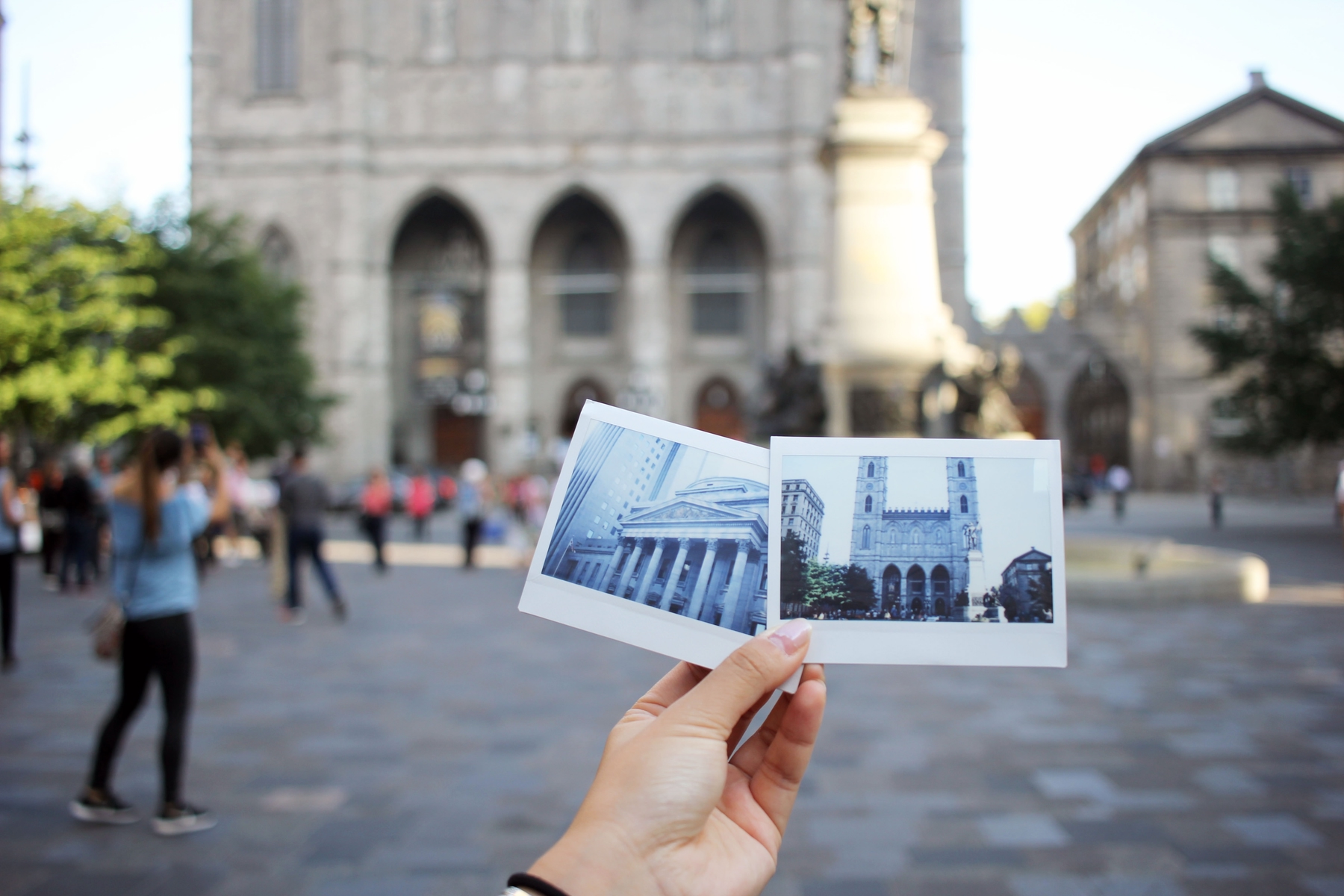 Person holding two polaroid images of Montreal architecture in front of Notre Dame Cathedral in the old port of Montreal, a great place to visit in Canada