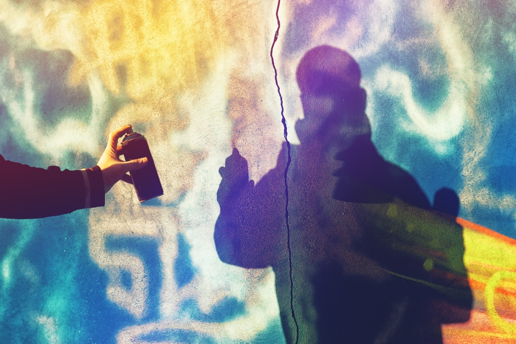 Graffiti artist spraying a wall with colour