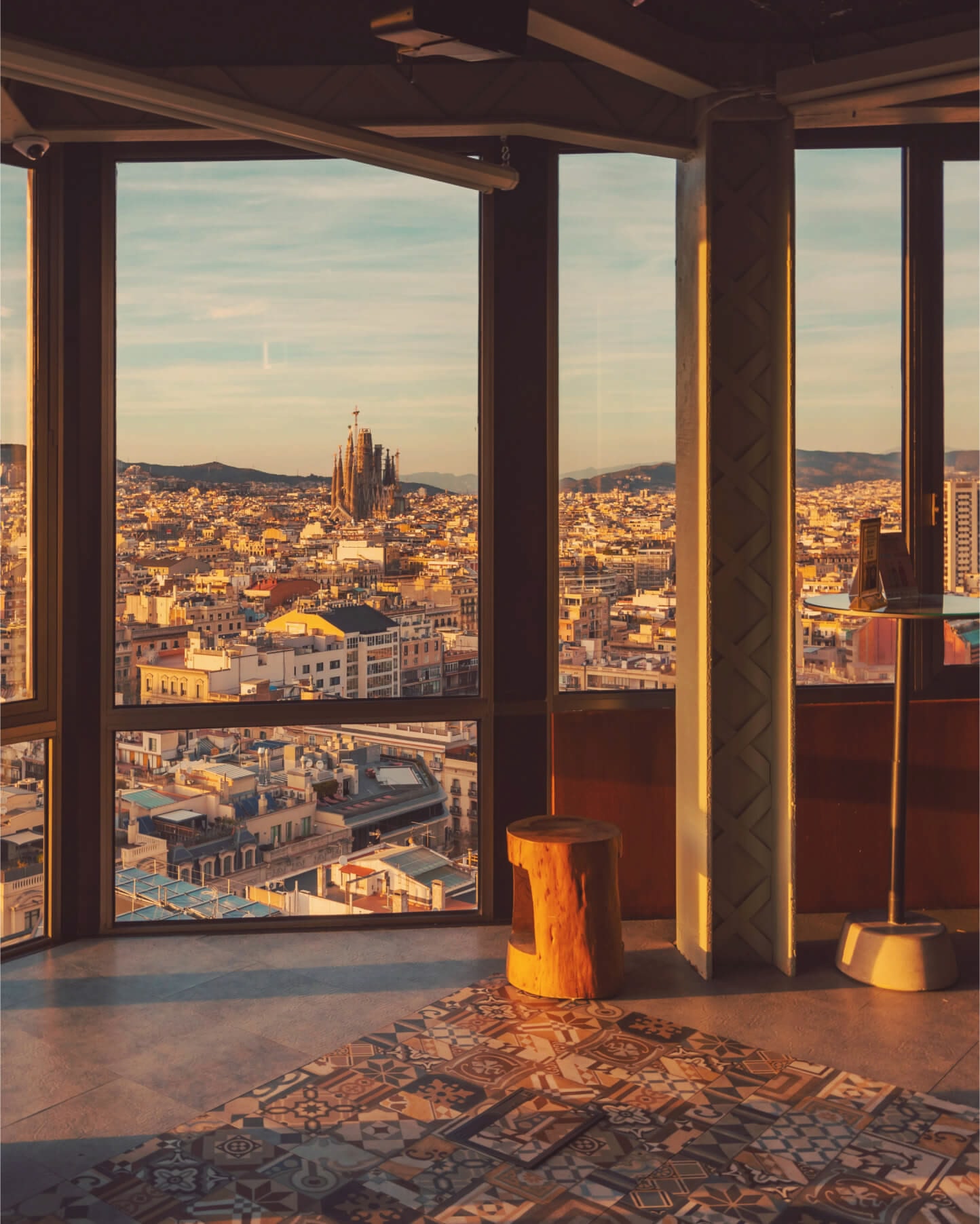 Window looking out across Barcelona towards La Sagrada Família at golden hour