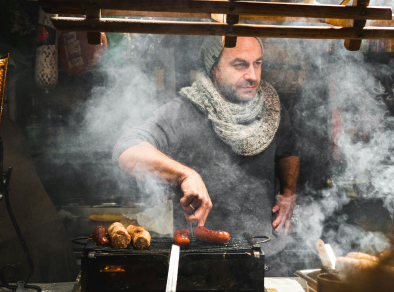 A man in cooking sausages