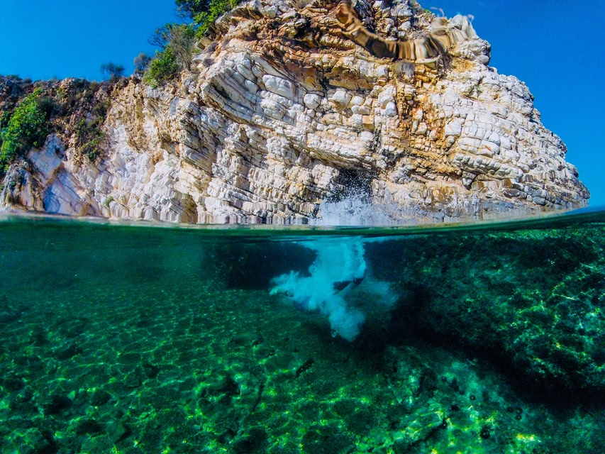 un voyageur qui plonge dans les eaux limpides à Saranda, Albanie