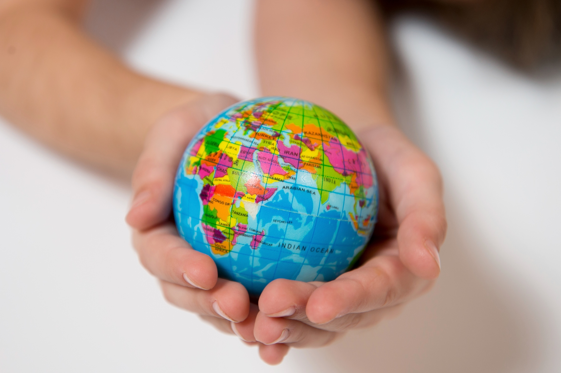 Person holding small globe in hands