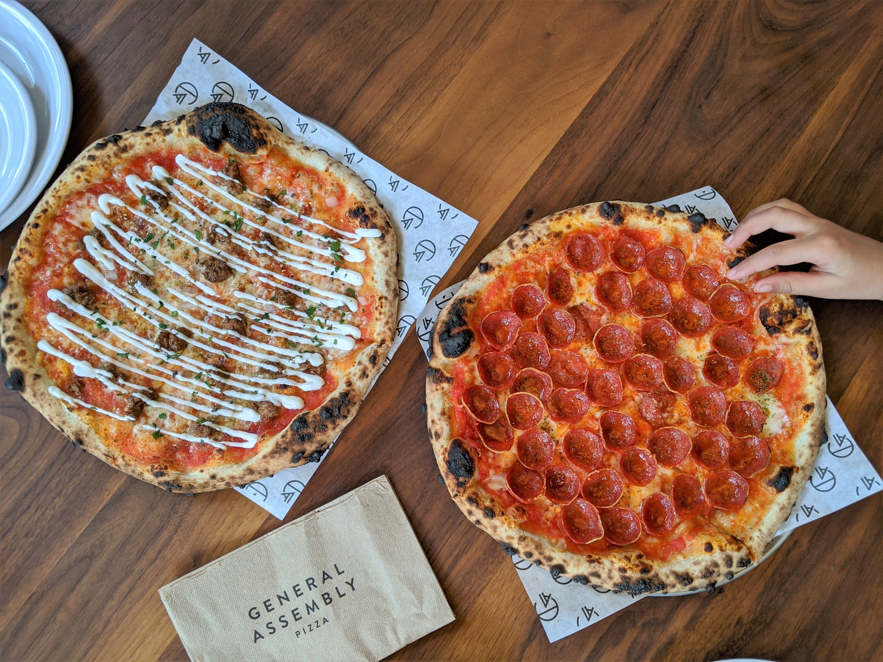 Hand grabbing wood fired pizza