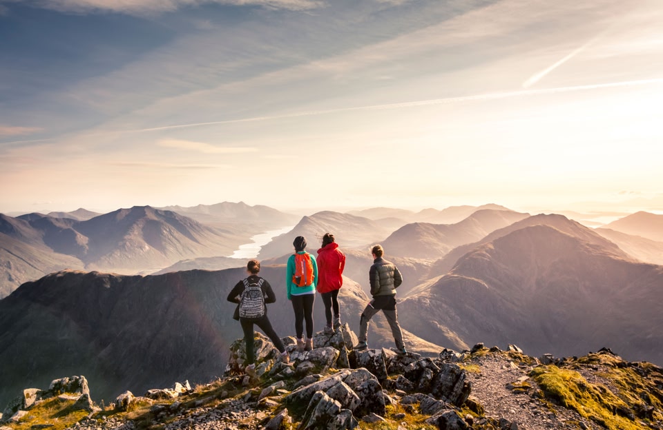 Four people standing on Bidean Nam Bian, highest point in the former county of Argyll, Glencoe, Scotland.