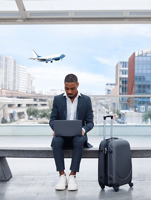 Man working on laptop in airport
