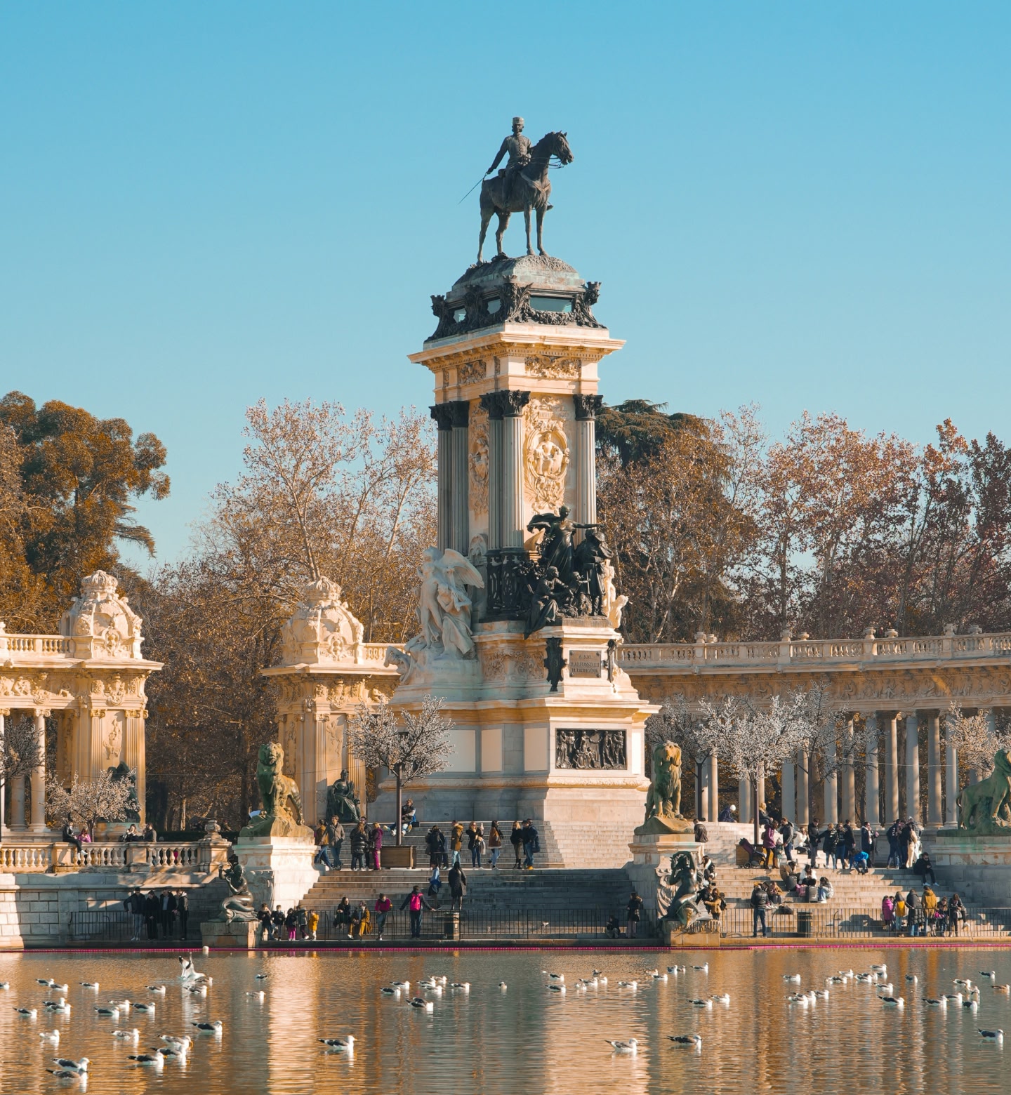 An equestrian statue overlooks a reflective lake in Madrid’s El Retiro Park.