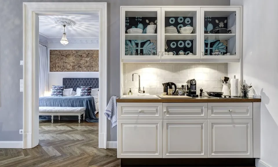 Una pequeña cocina en los apartamentos Gorki. Al fondo, la puerta del dormitorio está abierta.