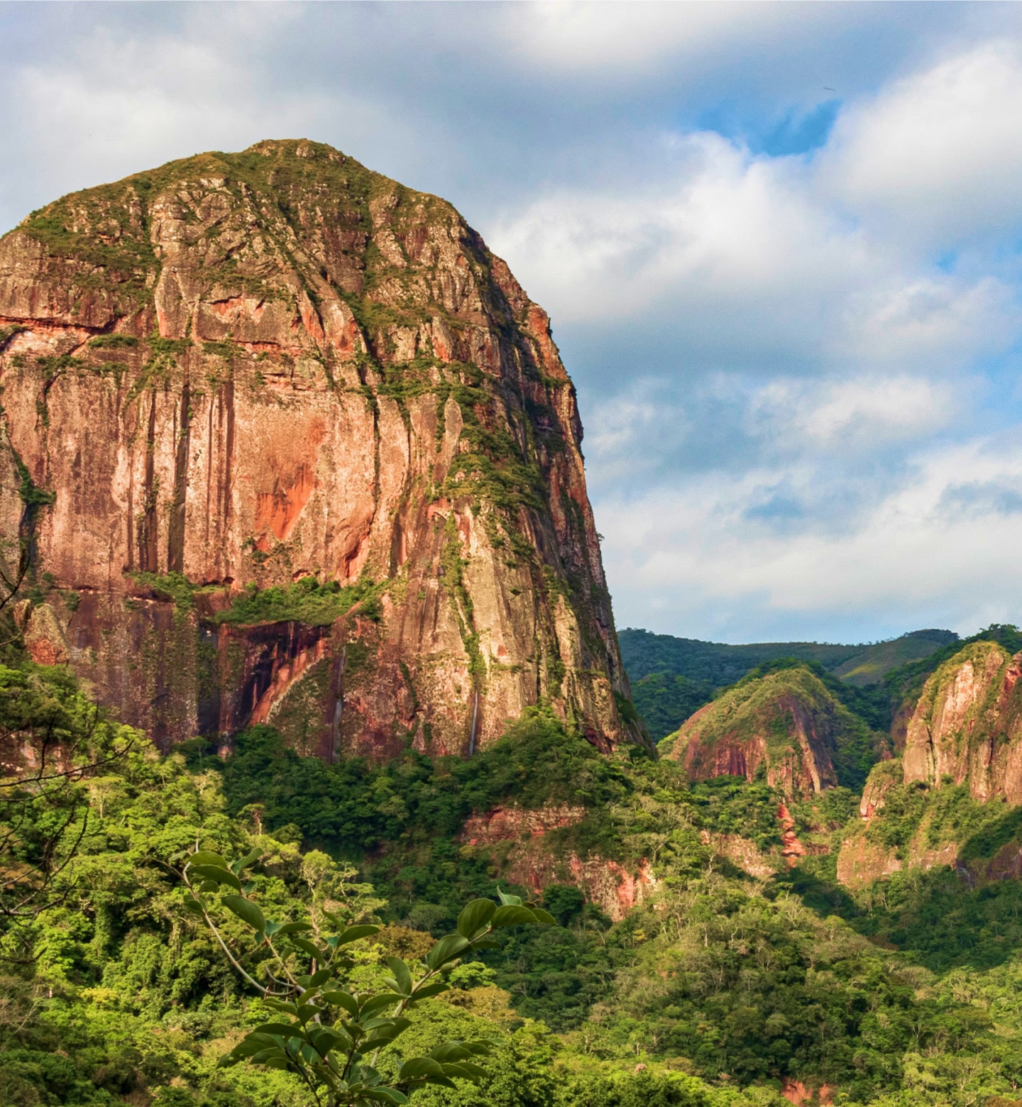 Uma imponente montanha de rocha vermelha cercada por uma floresta verdejante em Santa Cruz, Bolívia.
