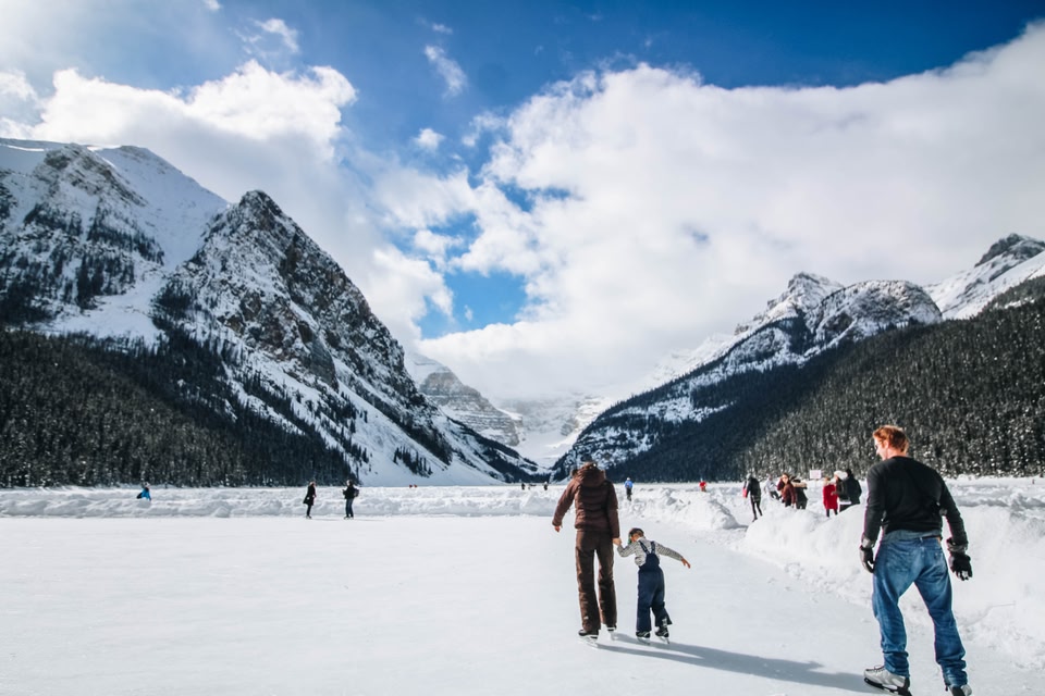 people ice skating on Lake Louise, Alberta, one of the best things to do in winter in Canada.