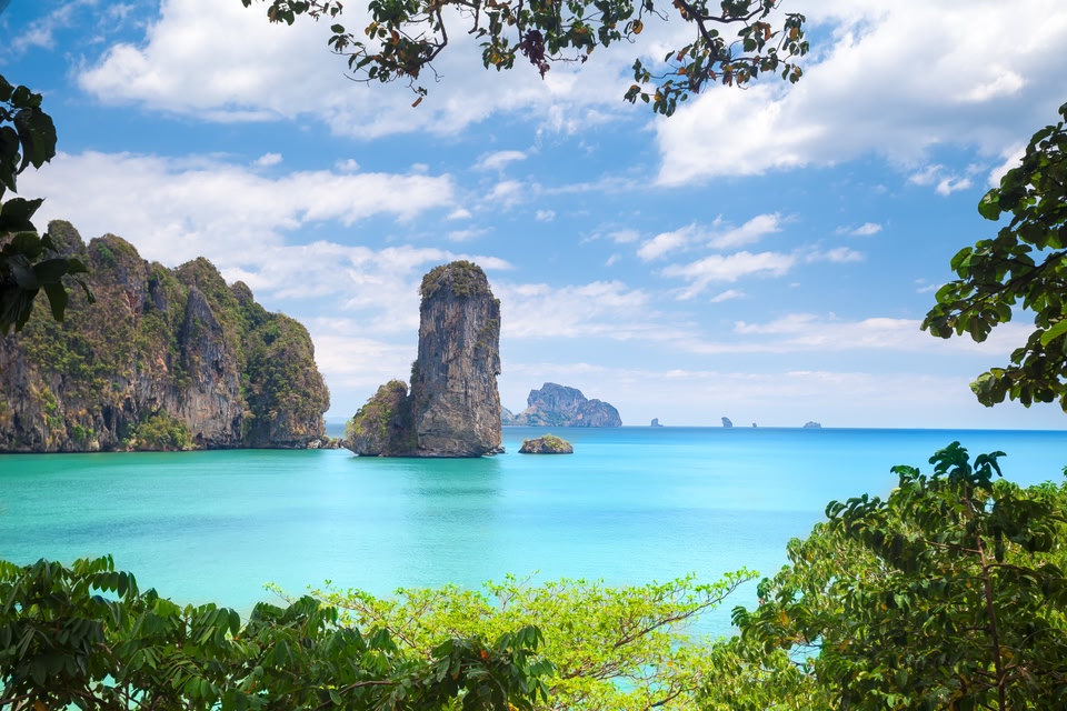 turquoise water and karst peaks in Krabi, Thailand on a sunny day.