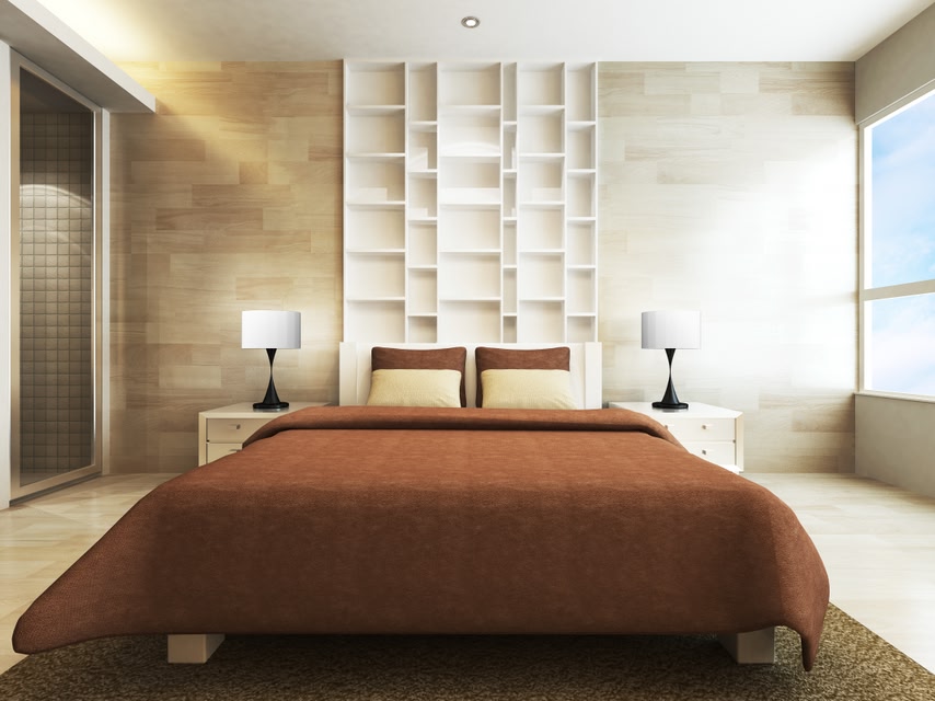 A well-made bed in a hotel room, flanked by nightstands with table lamps and a window to the right.