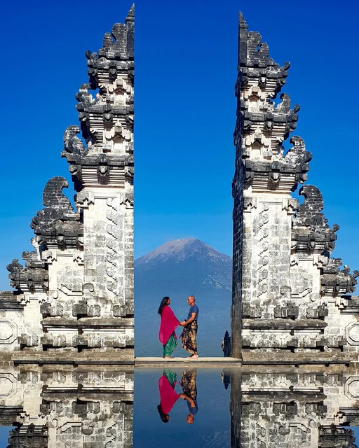 Ein Paar steht an dem Eingangstor eines Tempels auf Bali