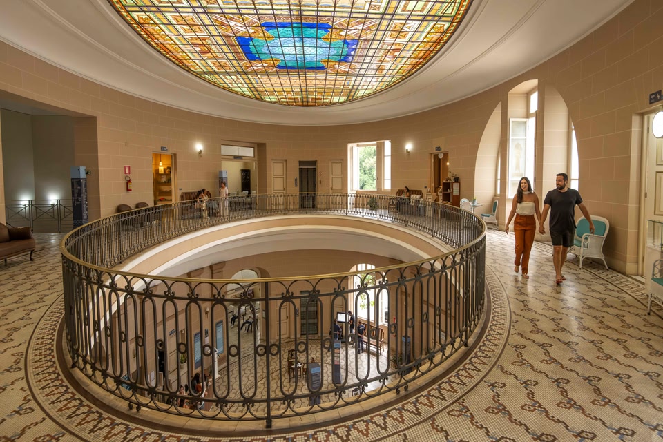 Casal caminha pela estrutura das termas de Poços de Caldas, viagens a dois