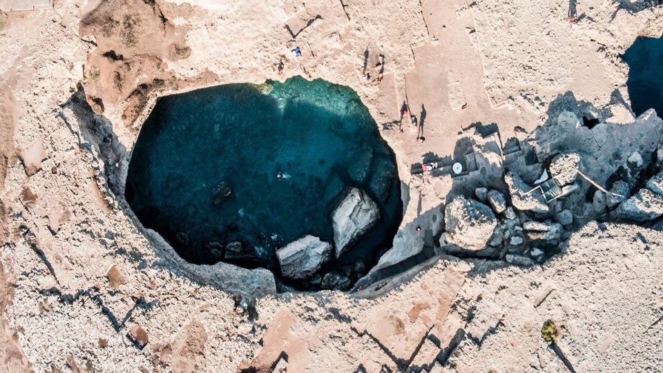 L'immagine mostra la Grotta della Poesia, una grotta carsica naturale vicino a Lecce, nel Salento. È considerata una delle piscine naturali più belle del mondo, con acqua turchese che scorre attraverso rocce calcaree.