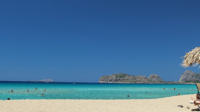 Een prachtig strand op Kreta met blauw water en een zandstrand.