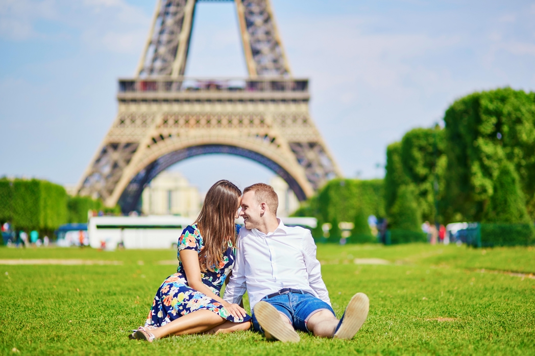 Couple on the grass in front of the Eiffel Tower in Paris