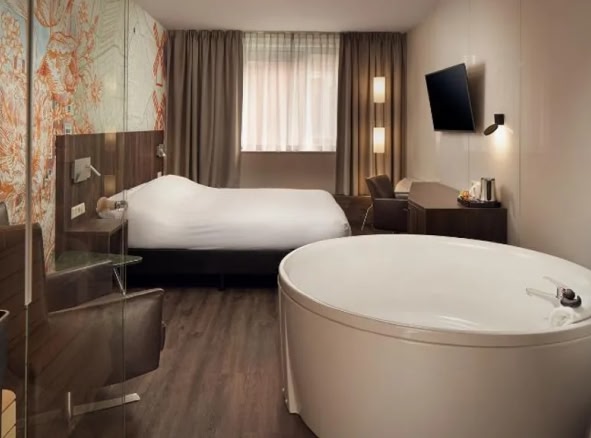 A hotel room with a large bath inside the room at the Inntel Hotels Amsterdam Centre