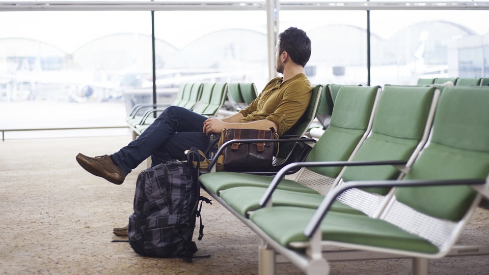 空港でベンチに座る男性