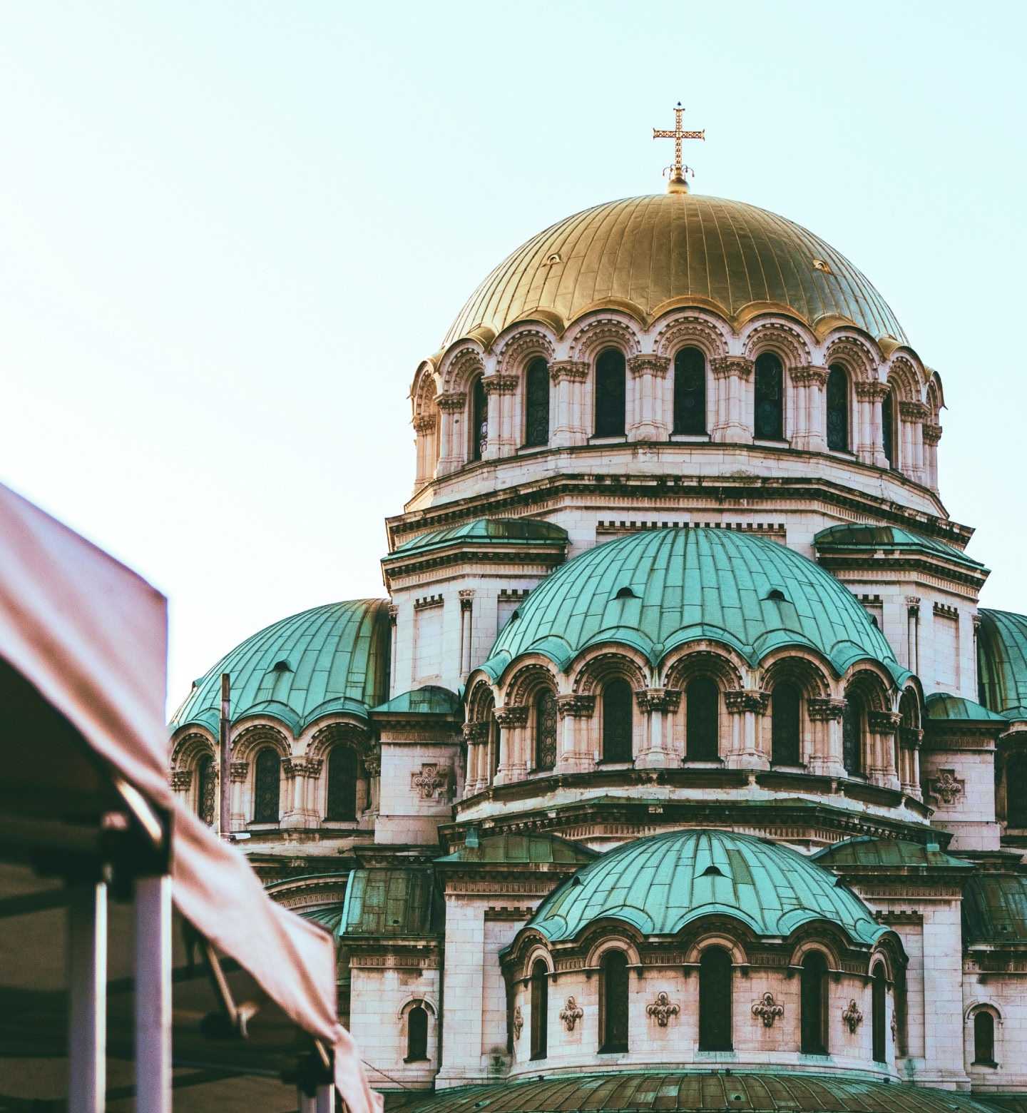 Une cathédrale avec un dôme doré et des toits verts sous un ciel dégagé à Sofia, en Bulgarie.