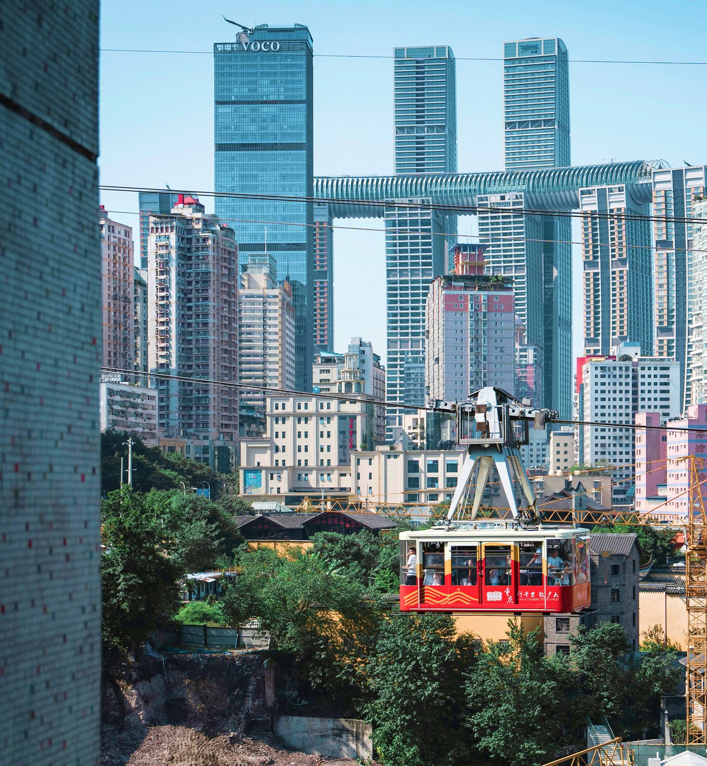중국 충칭의 현대적인 고층 빌딩 사이를 지나는 빨간색 케이블카