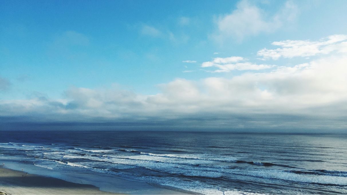 Ein Bild eines wunderschönen Strandes mit blauem Himmel und blauem Meerwasser bei Tag.