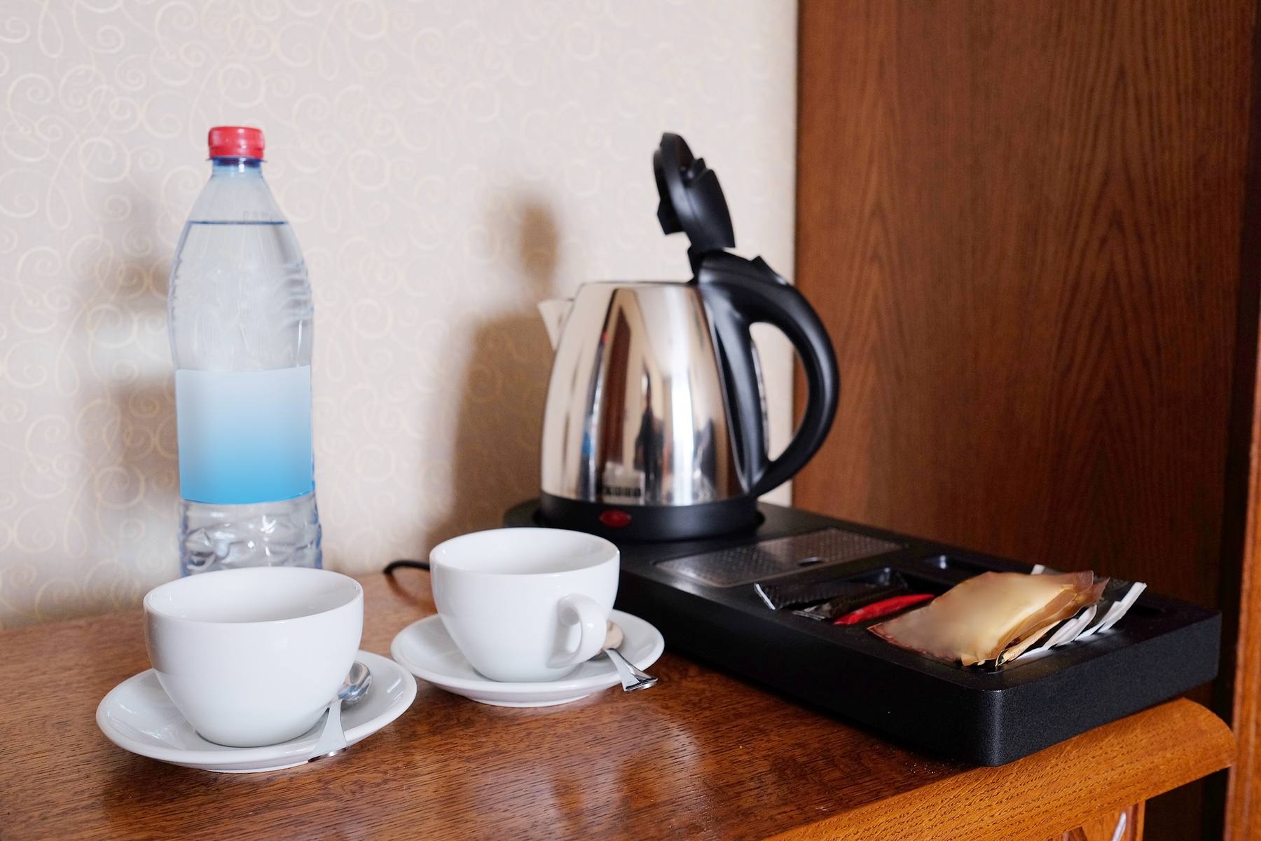 Plastic water bottle on counter next to tea kettle