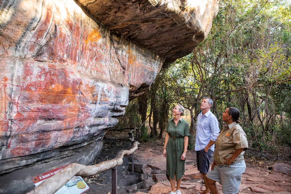 Couple looking at rock art with guide in Northern Territory