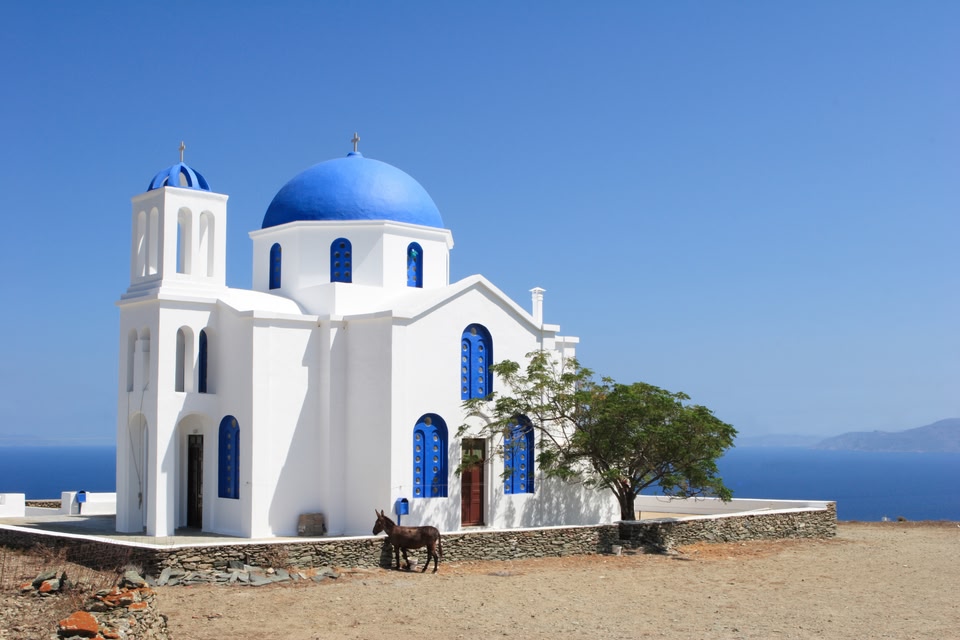 Λευκό εκκλησάκι με γαλάζιο τρούλο και θεά στη θάλασσα, Φολέγανδρος