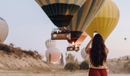 Woman taking a picture of a hot air balloon