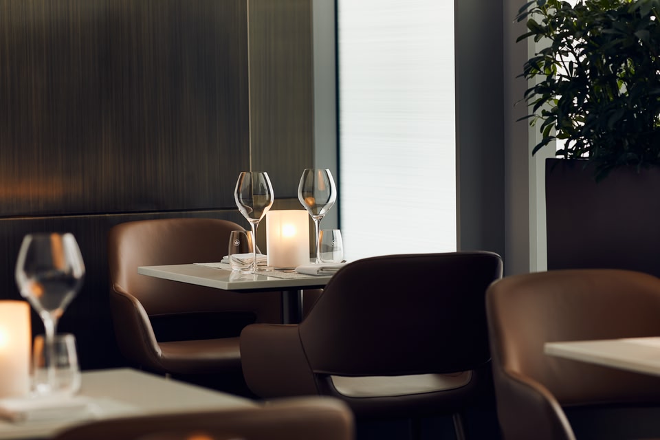 two glasses of wine at a table in Air Canada's Signature Suite Lounge at Toronto Pearson Airport.