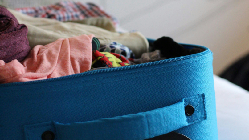 Openstaande turquoise koffer met inhoud
