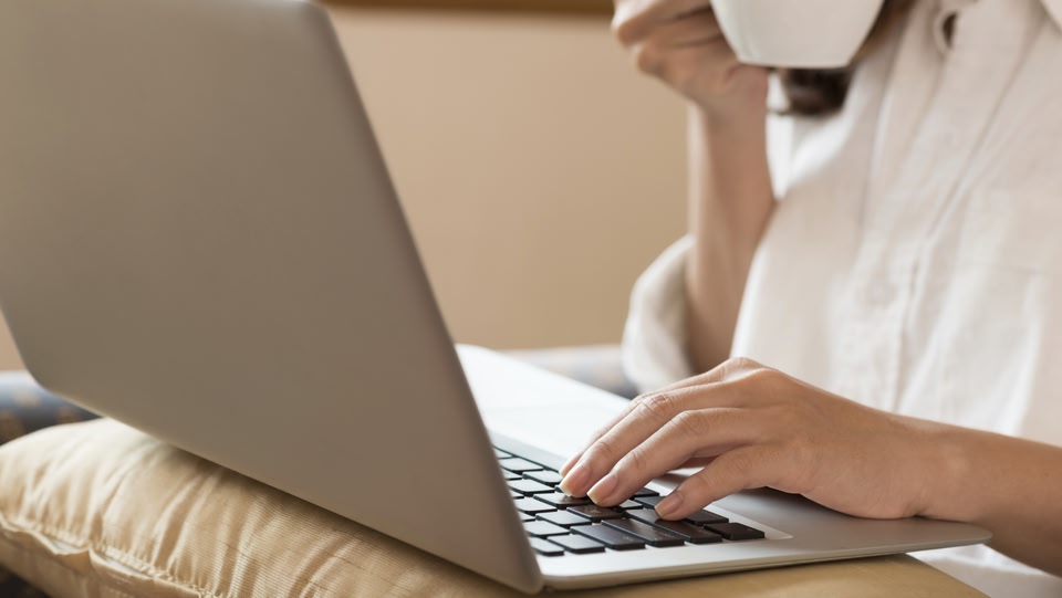 a person's hands typing on a laptop keyboard.