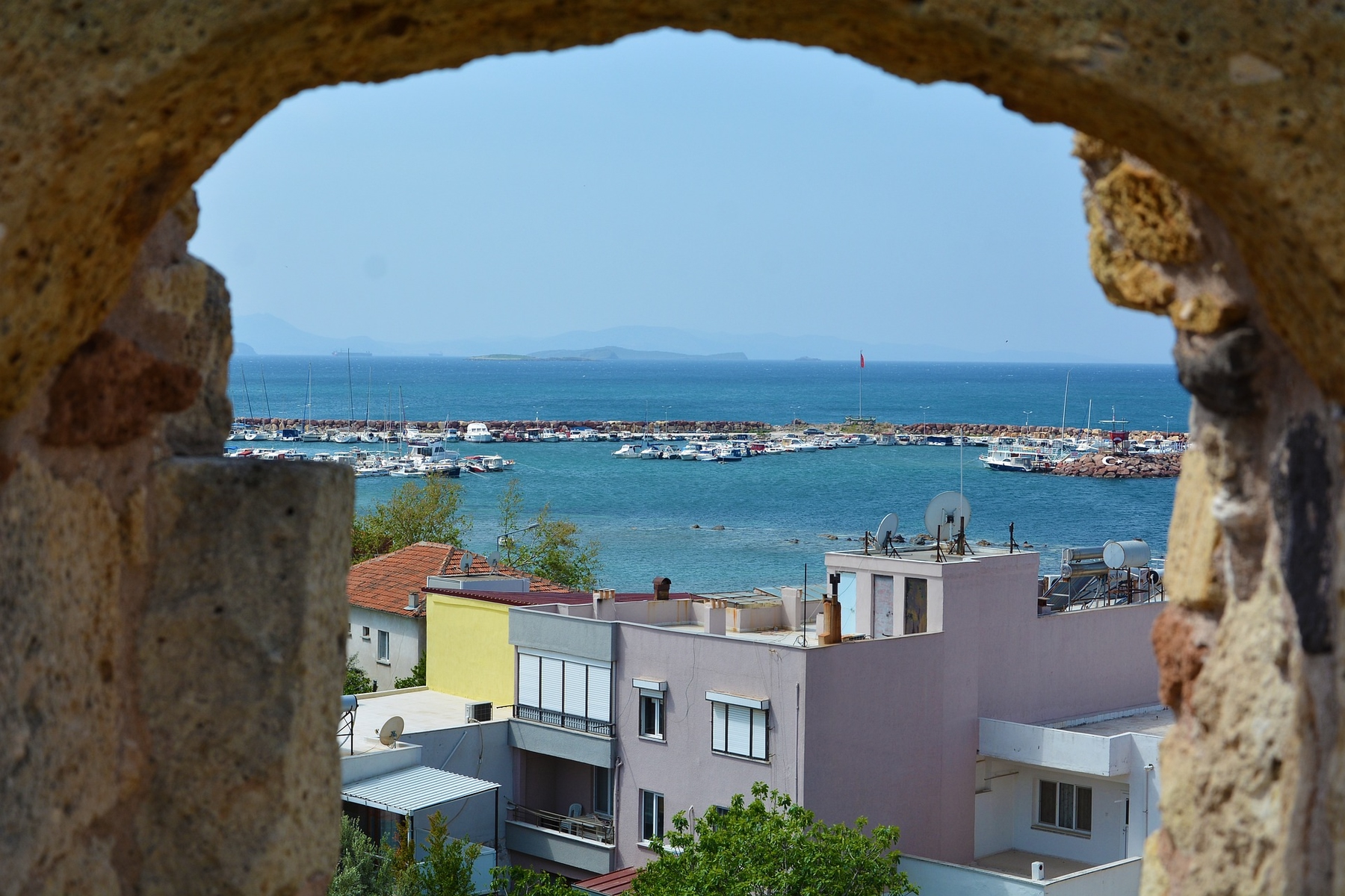 view from above of Izmir coastline on a sunny day, colourful buildings in the background.