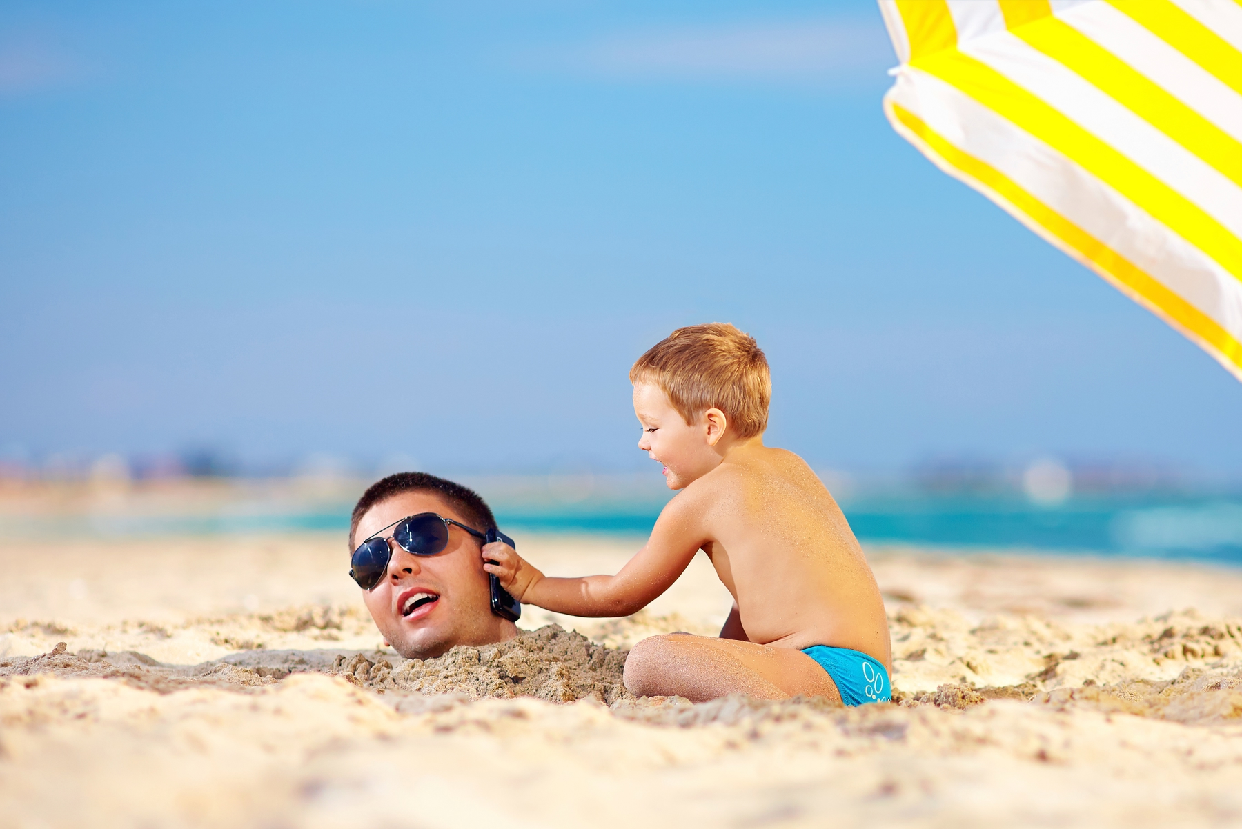 Vater und Sohn in den Sommerferien am Strand