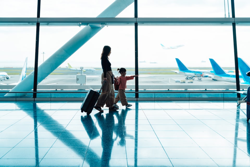 mamma e figlia camminano in un aeroporto