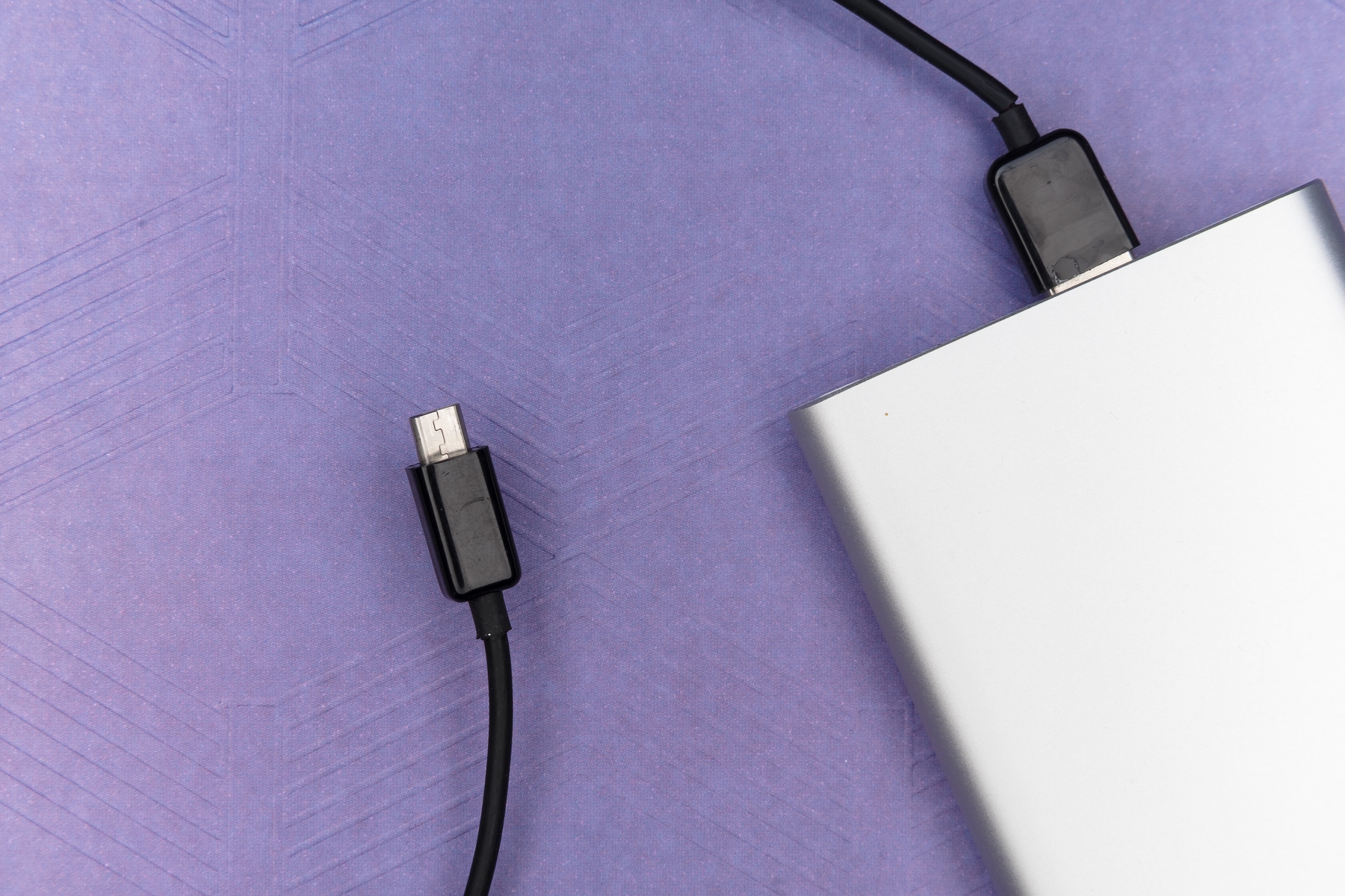 close up of travel power bank with a purple background.