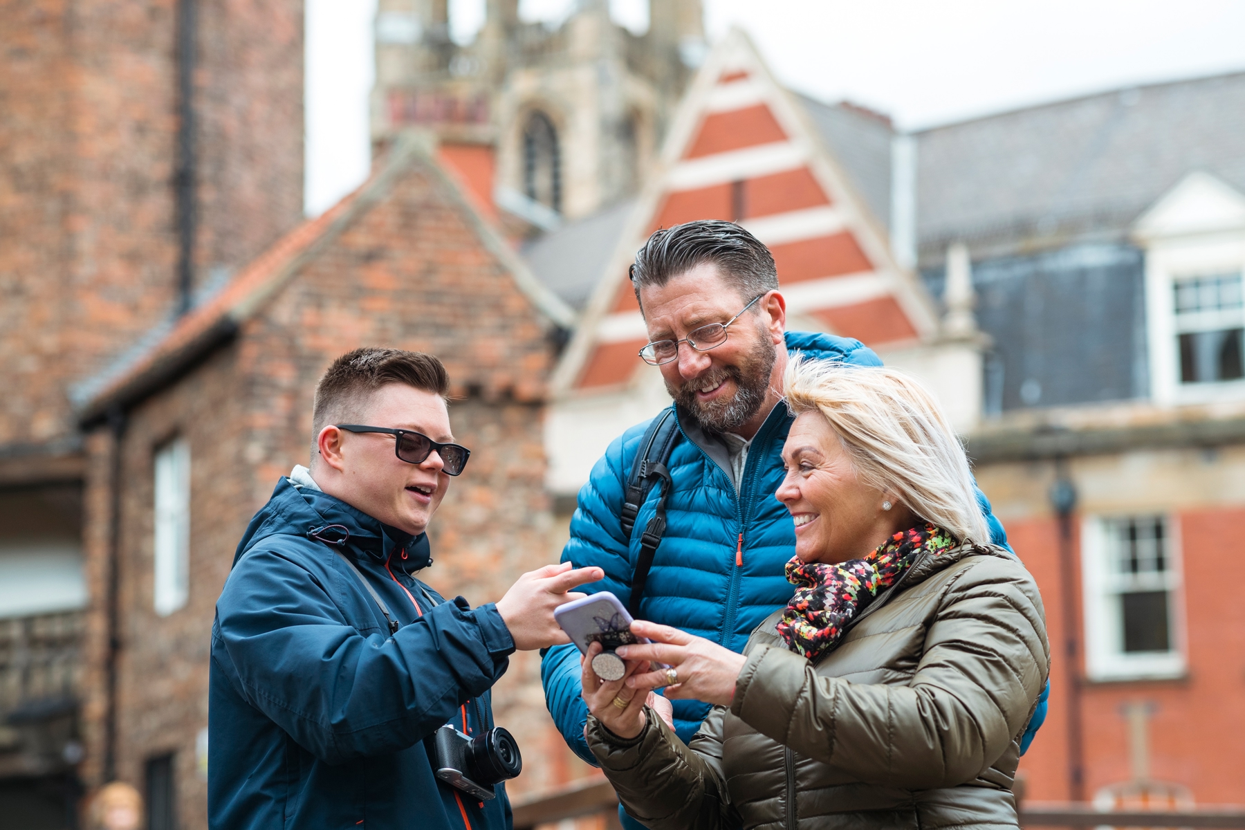 Three people looking at a phone