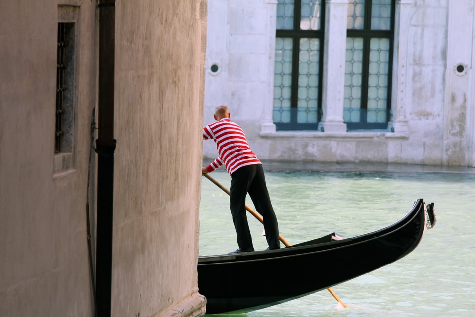 Gondolier in red and white striped shirt in Venice, Italy