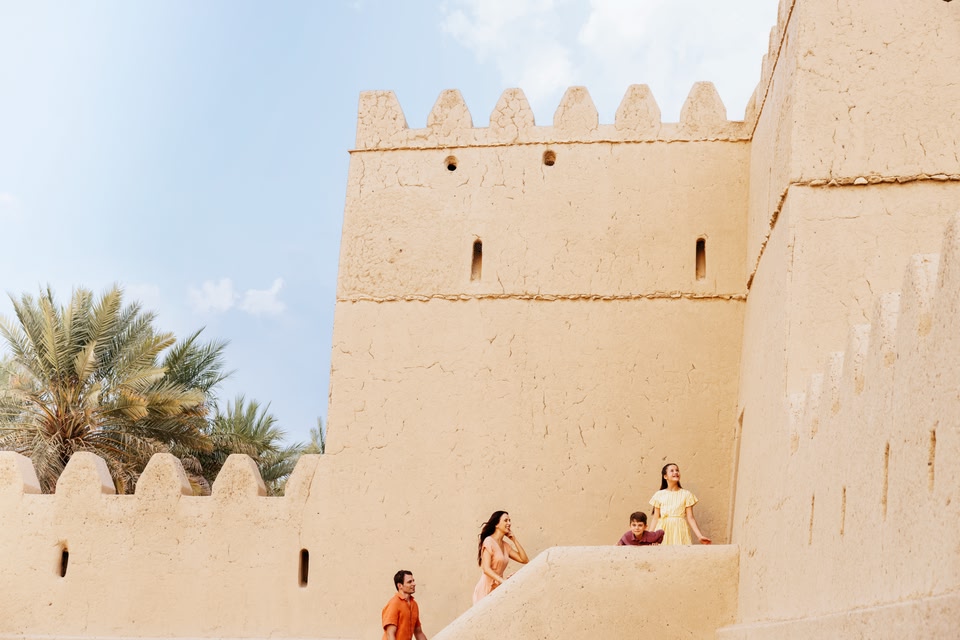 Une famille se tient sur un escalier à Qasr Al Muwaiji, un fort du 20e siècle qui exprime la culture d'Abu Dhabi.