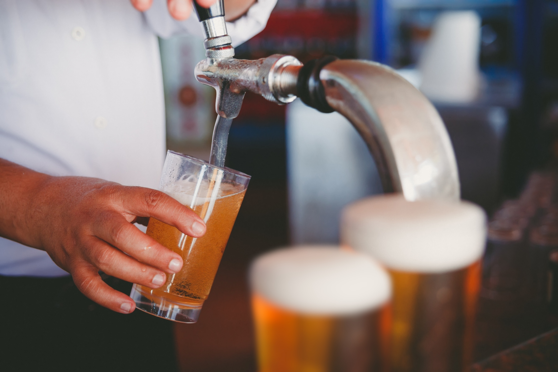 bartender pouring pints of beer on tap