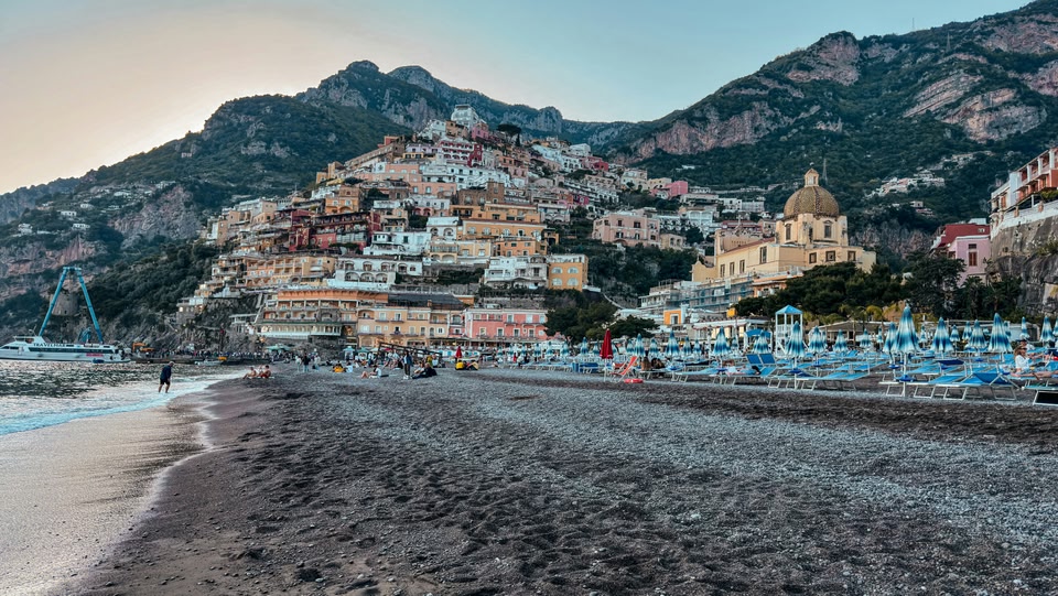 Spiaggia a Positano, Italia, con edifici colorati sulla collina.