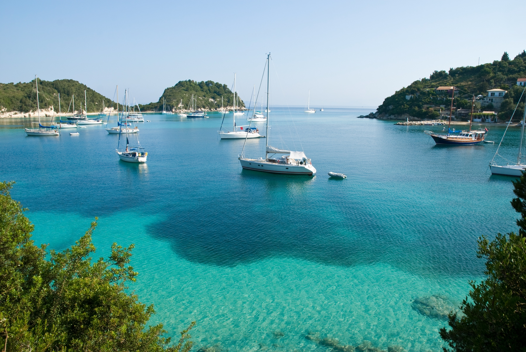 Yachts resting in the turquoise waters of Greece. Sailing is one of the best adventure holidays in the UK and abroad