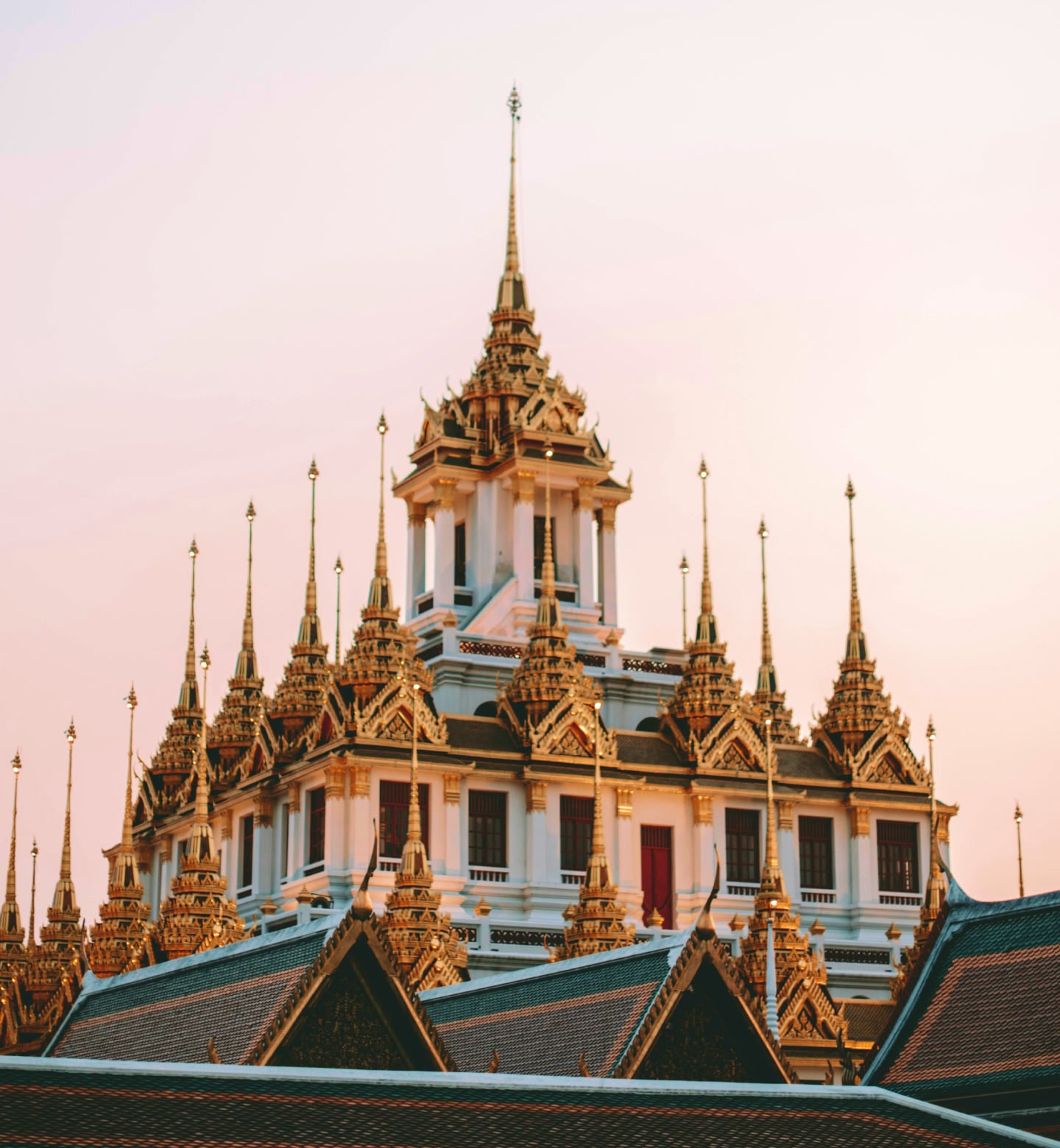 Le splendide guglie dorate di un tempio che brillano sotto il cielo sereno di Bangkok.